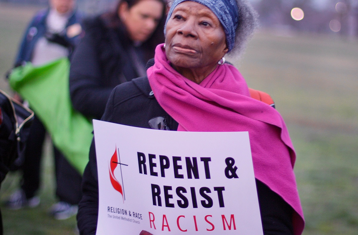 A woman holds a sign during an April 4, 2018, peace and unity rally. The rally followed the Commission on Religion and Race’s participation in the United to End Racism Prayer Walk in Washington. Photo courtesy of the Commission on Religion and Race.
