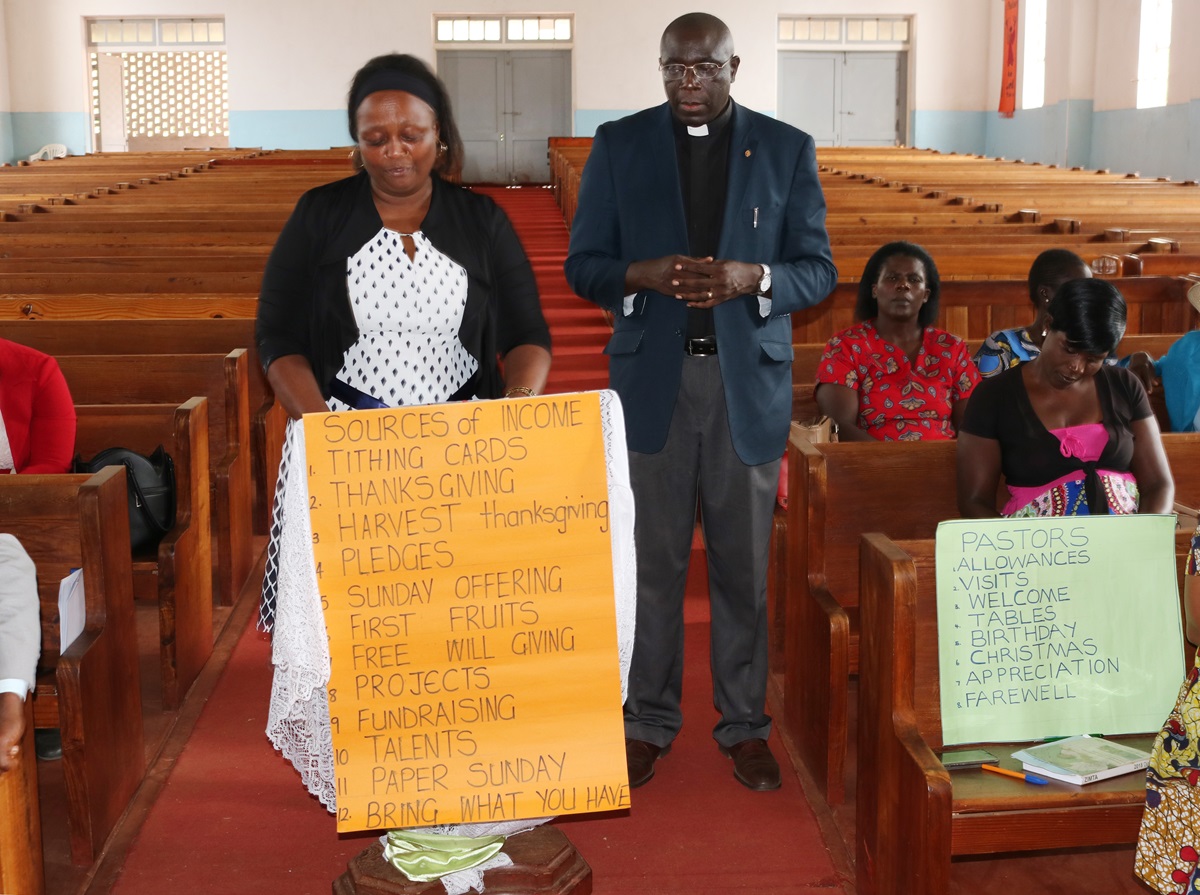 Kuda Dozva (holding sign) talks about fundraising and pastoral care during training held in Harare, Zimbabwe, for church leaders from the South Congo Conference. Photo by Chenayi Kumuterera, UMNS.