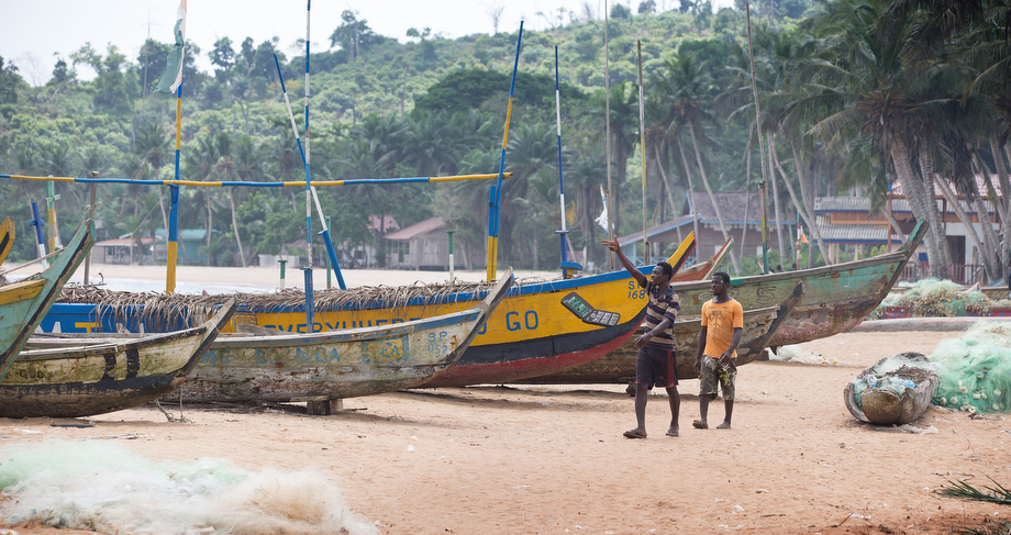 Fishermen walk past their boats in Monogaga.