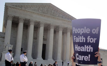 A demonstrator holds a sign in front of the U.S. Supreme Court in favor of the U.S. healthcare legislation, which the court upheld last year. A 2012 file photo by Michelle Whittaker/ United Methodist Board of Church and Society.