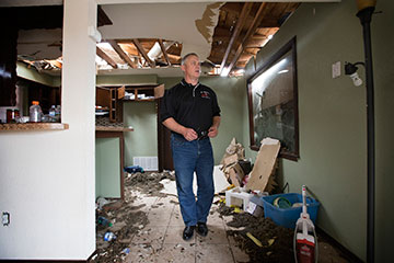 The Rev. D.A. Bennett surveys tornado damage at the home of parishioner Trent Steward in Moore, Okla.