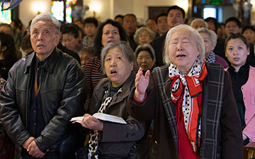 Shen Lu de (right foreground) joins with fellow worshippers to sing a hymn at Chongwenmen Church in Beijing. The church was established in 1870 by U.S. Methodists and was then known as Asbury Church.