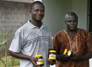 Duke Nyaeh and Ezekiel C. Freeman display their finished product, Liberian honey. Other sustainable products in Liberia include raising snails and using roots and leaves from the Moringa tree.
