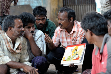 Simon Charles, an educator with the Madras Christian Council of Social Service, meets with fishermen at the dock in Chennai, India, in March 2010 to explain HIV and AIDS.