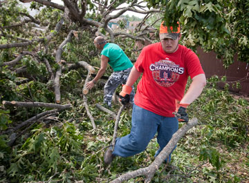 Volunteers Jacob Burrow (front) and Mark Swyden clear trees downed by the tornado in Joplin, Mo., in May 2011. In 2011, volunteers organized through the Missouri Conference contributed 16,371 hours to Joplin's recovery.