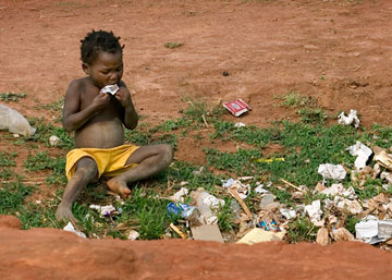 A child scavenges for food in a garbage pit near Malanje, Angola. Advocates working to end hunger say enough food is produced globally to adequately feed everyone around the world. A UMNS photo by Mike DuBose.