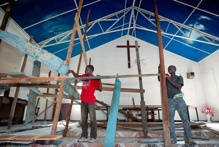 Jean Vixommol (left) and Cerant Wichtlander erect scaffolding to make repairs inside the sanctuary of the Methodist church in Petit-Goâve.