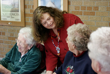 The Rev. Kathy Hammond visits with nursing home residents after a weekday Bible study in Kenmare, N.D. A UMNS photo by Jan Snider.