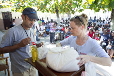 Sharad Aggarwal (left) and Melissa Crutchfield of UMCOR unpack a food ration in Mellier, Haiti.