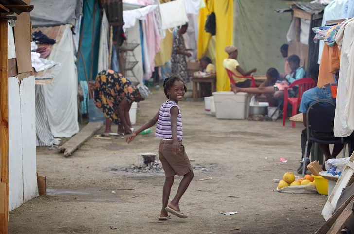A girl plays between rows of makeshift homes at a temporary camp in the soccer stadium at Leogane, Haiti. A UMNS photo by Mike DuBose.