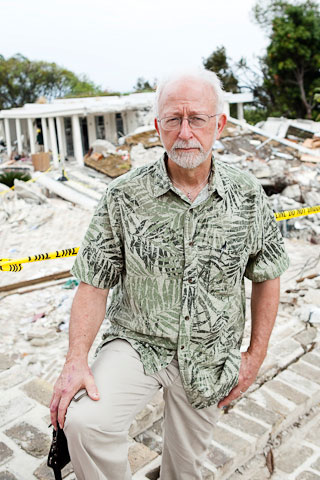 The Rev. James Gulley stands in front of the wreckage of the Hotel Montana. A UMNS photo by Jen Judge.