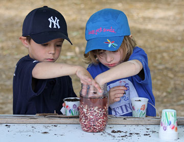 Two kids plant seeds at the Children's Pow Wow in Houston in 2009. A UMNS photo by Ronny Perry.