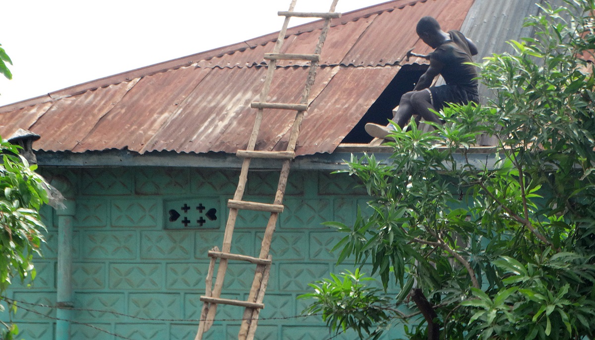 A carpenter repairs a roof in Bo, Sierra Leone, following a storm that destroyed many buildings and left much of the city without power. Photo by Phileas Jusu, UMNS.