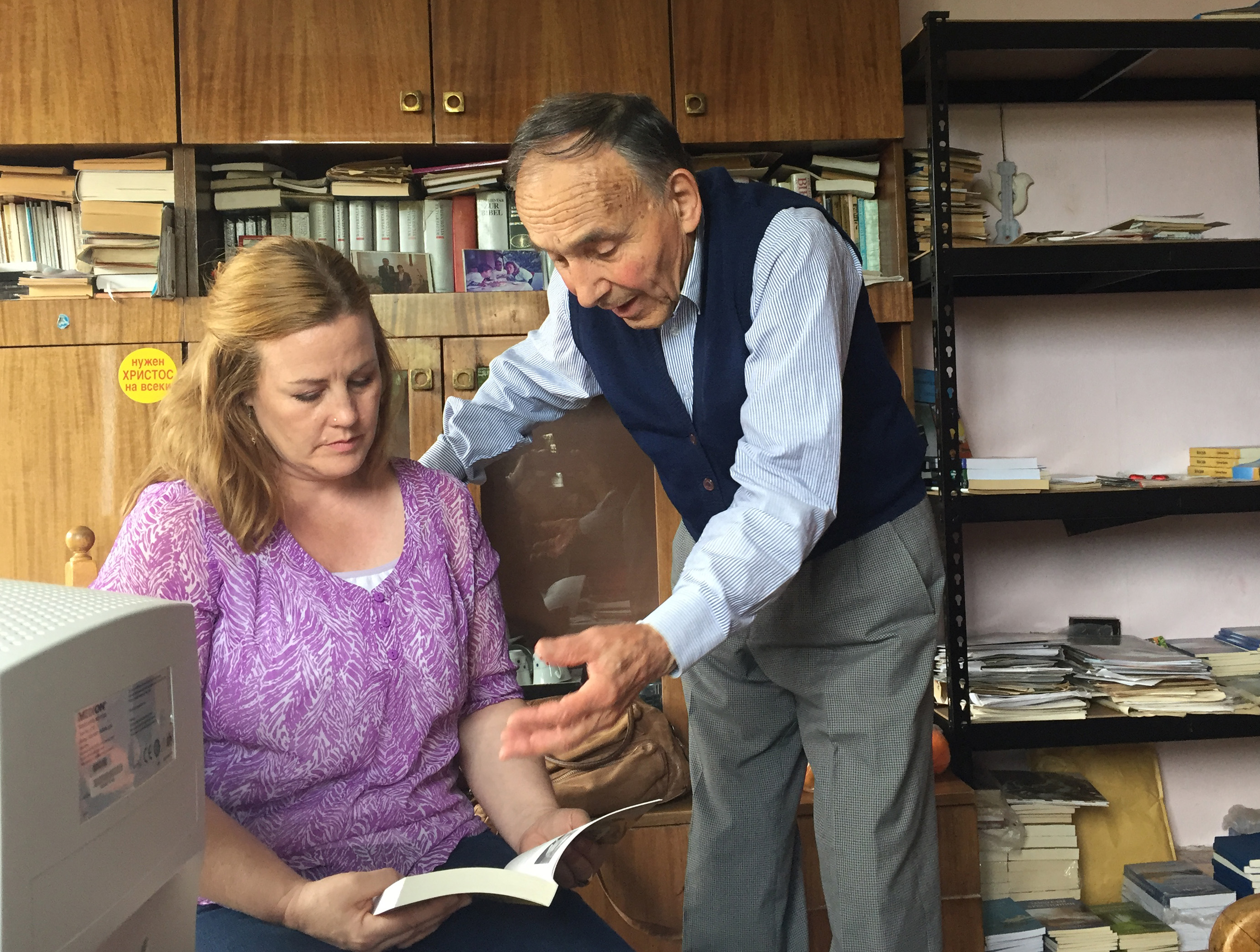 The Rev. Bodijar Popov shows the Rev. Jessica Morris-Ivanova one of his father’s books. Father and son, Simeon and Bodijar Popov, both served Shumen Methodist Church in Bulgaria. Photo by Ginny Whitehouse.