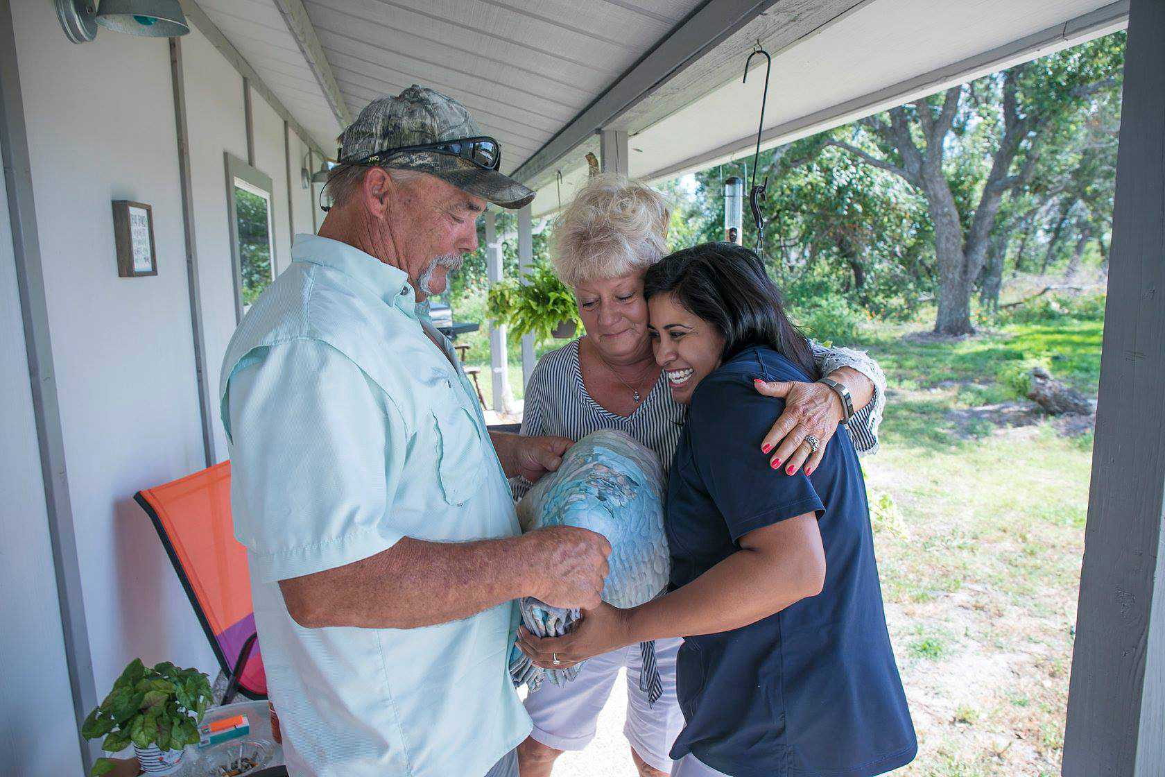 Kim and Donna Hines of Rockport, Texas, who lost their home in Hurricane Harvey, accept a quilt from Zelina Alvarado, a case management worker from the Rio Texas Conference. The conference was able to find financing and volunteer labor that helped the couple make a new home from their garage and a second structure on their property. Photo courtesy of the Rio Texas Conference.