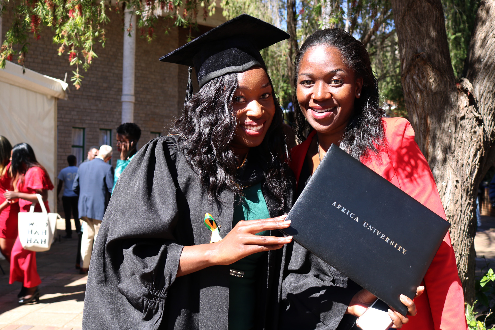 Gracious Matika (left) and her sister, Varaidzo, pose with her new diploma after Africa University’s June 9 graduation ceremony. Photo by Eveline Chikwanah, UMNS.