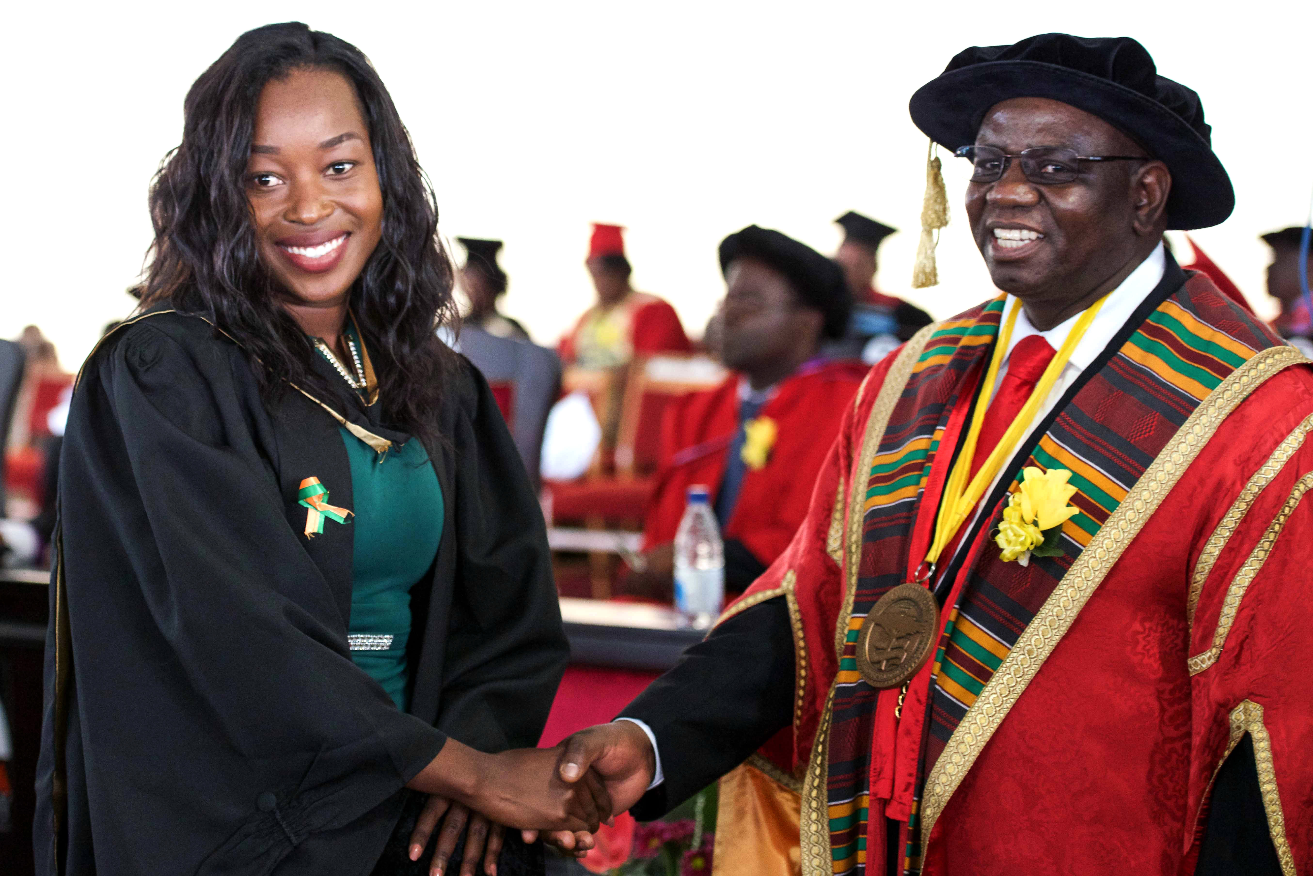 Gracious Matika shakes hands with Africa University Vice Chancellor Munashe Furusa M. Furusa after she graduated on June 9. Photo courtesy of Information and Public Affairs Office, Africa University.