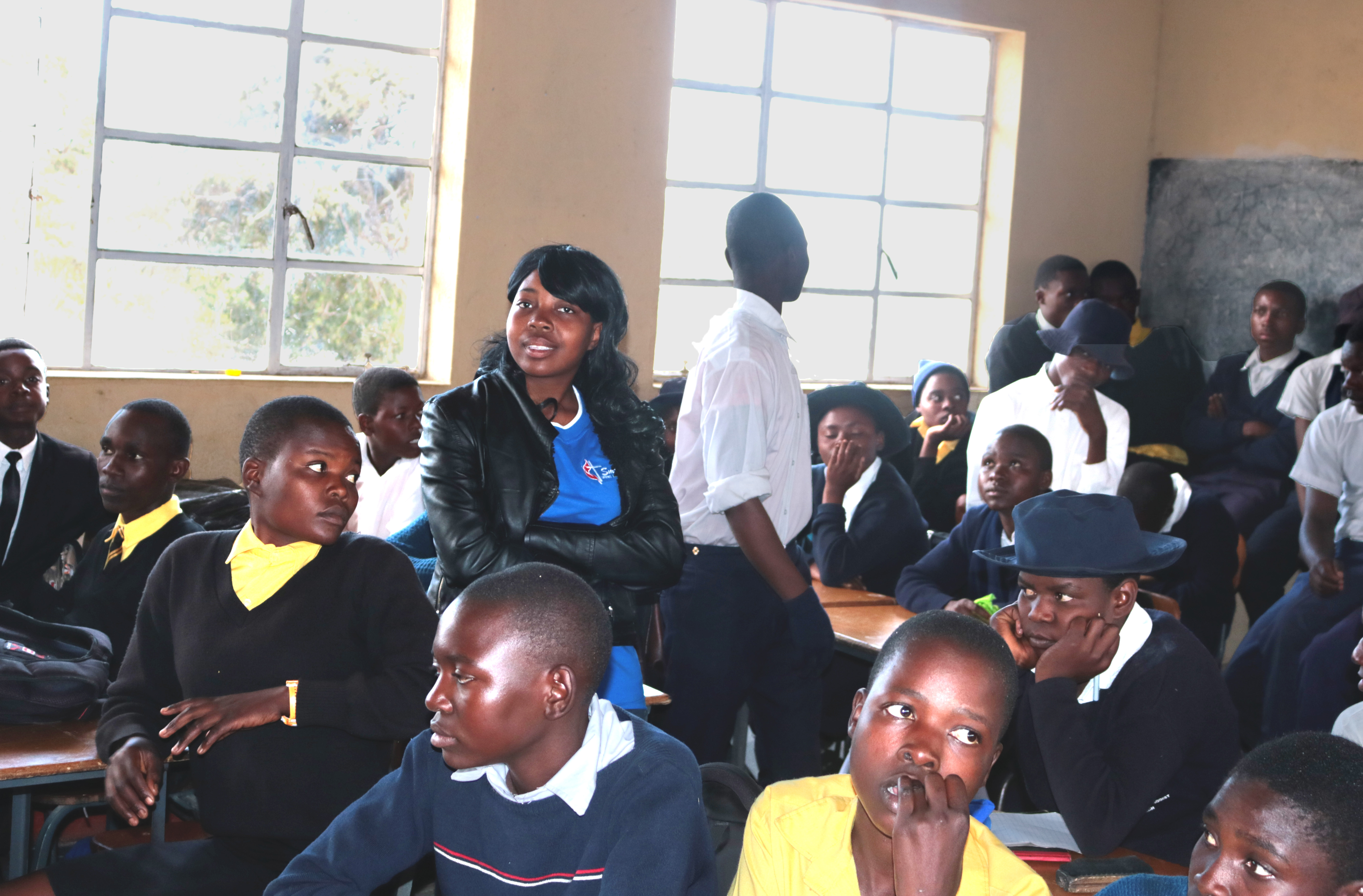 Students from the University of Zimbabwe sit with secondary school-level students in a classroom at Mashambanhaka Secondary Mission School. The college students are part of the United Methodist-supported ministry, Partners for Success, that is mentoring more than 250 younger students. Photo by Chenayi Kumuterera, UMNS. 