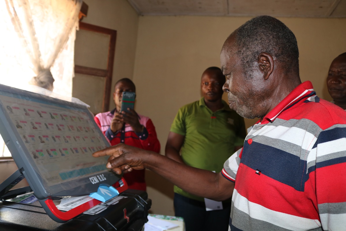 The Rev. Kanda Salumu examines an electronic voting machine during a demonstration in Kindu, Congo. The United Methodist Church is helping educate pastors and laypeople about the machines, which are unfamiliar to many Congolese. Photo by Chadrack Tambwe Londe, UMNS.  The Rev. Kanda Salumu examines an electronic voting machine during a demonstration in Kindu, Congo. The United Methodist Church is helping educate pastors and laypeople about the machines, which are unfamiliar to many Congolese. Photo by Chadrack Tambwe Londe, UMNS.