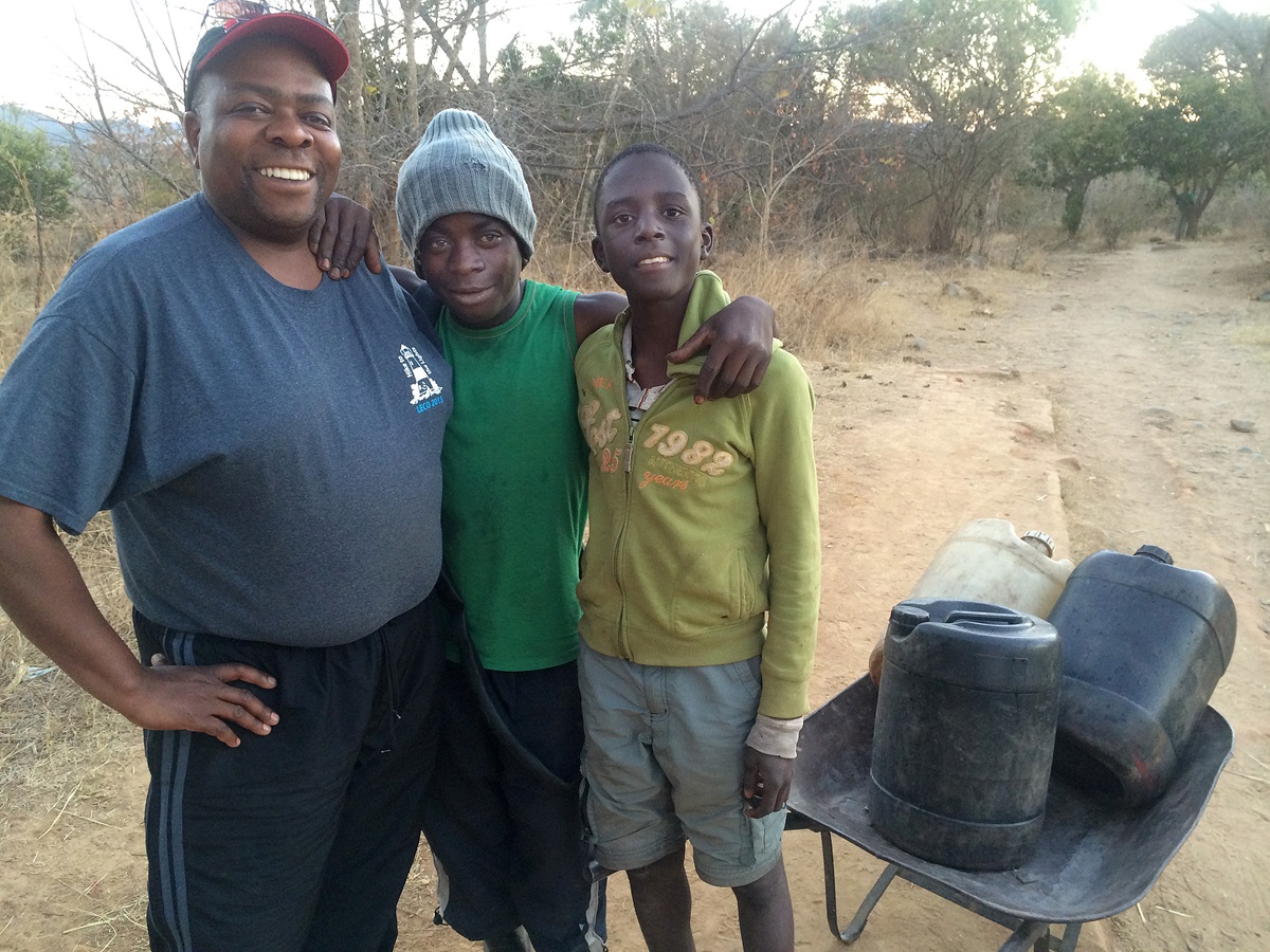 Farai Rukunda visits with students Kudakwashe Nhunama (center) and Maxwell Mukeredzi during his first visit to Arnoldine Mission in August of 2014. Photo courtesy of Living Beyond Hope.  Farai Rukunda visits with students Kudakwashe Nhunama (center) and Maxwell Mukeredzi during his first visit to Arnoldine Mission in August of 2014. Photo courtesy of Living Beyond Hope.