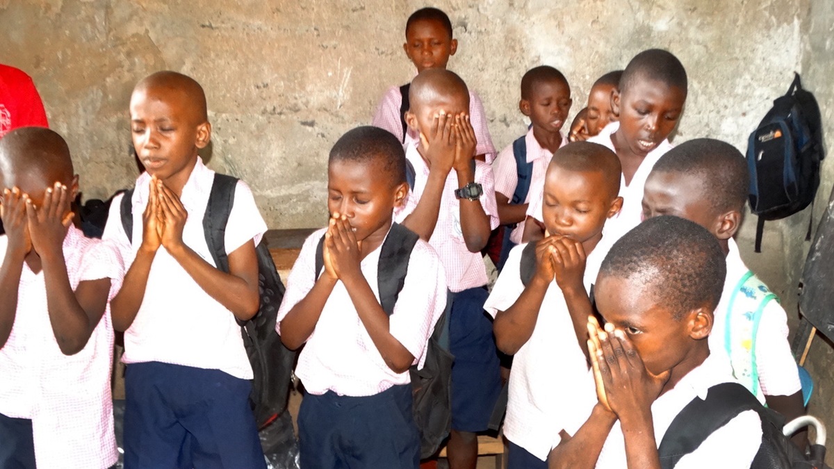 Students at Hope Primary School in Kamayama, Sierra Leone, pray for the health of United Methodist Bishop John K. Yambasu. They also thanked God for the United Methodist Committee on Relief for providing the money to purchase new learning materials for the school. Photo by Phileas Jusu, UMNS. 