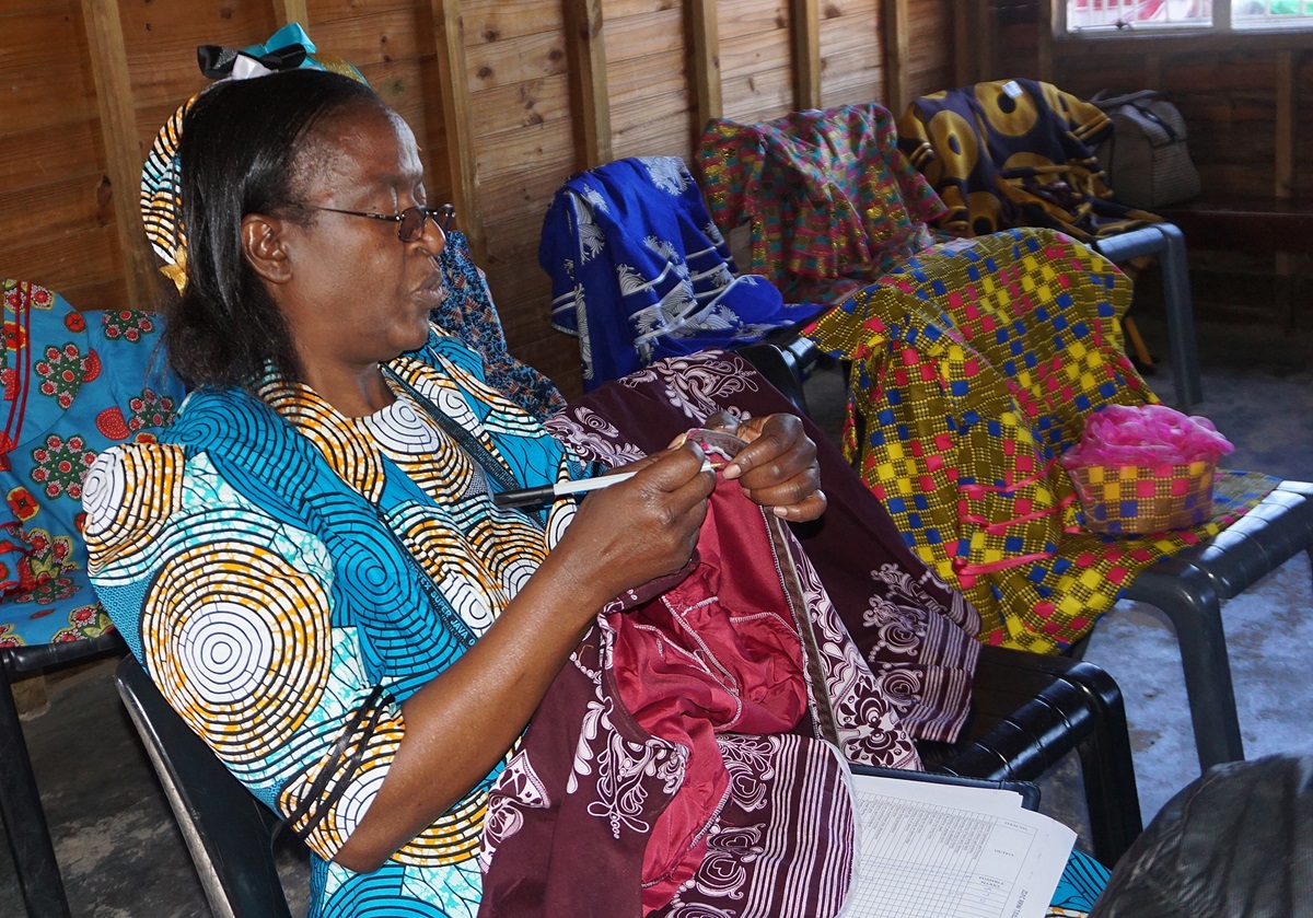 Evelyn Musewe inspects clothing made by United Methodist Women following a livelihood skills training  in Harare, Zimbabwe. Photo by Kudzai Chingwe.