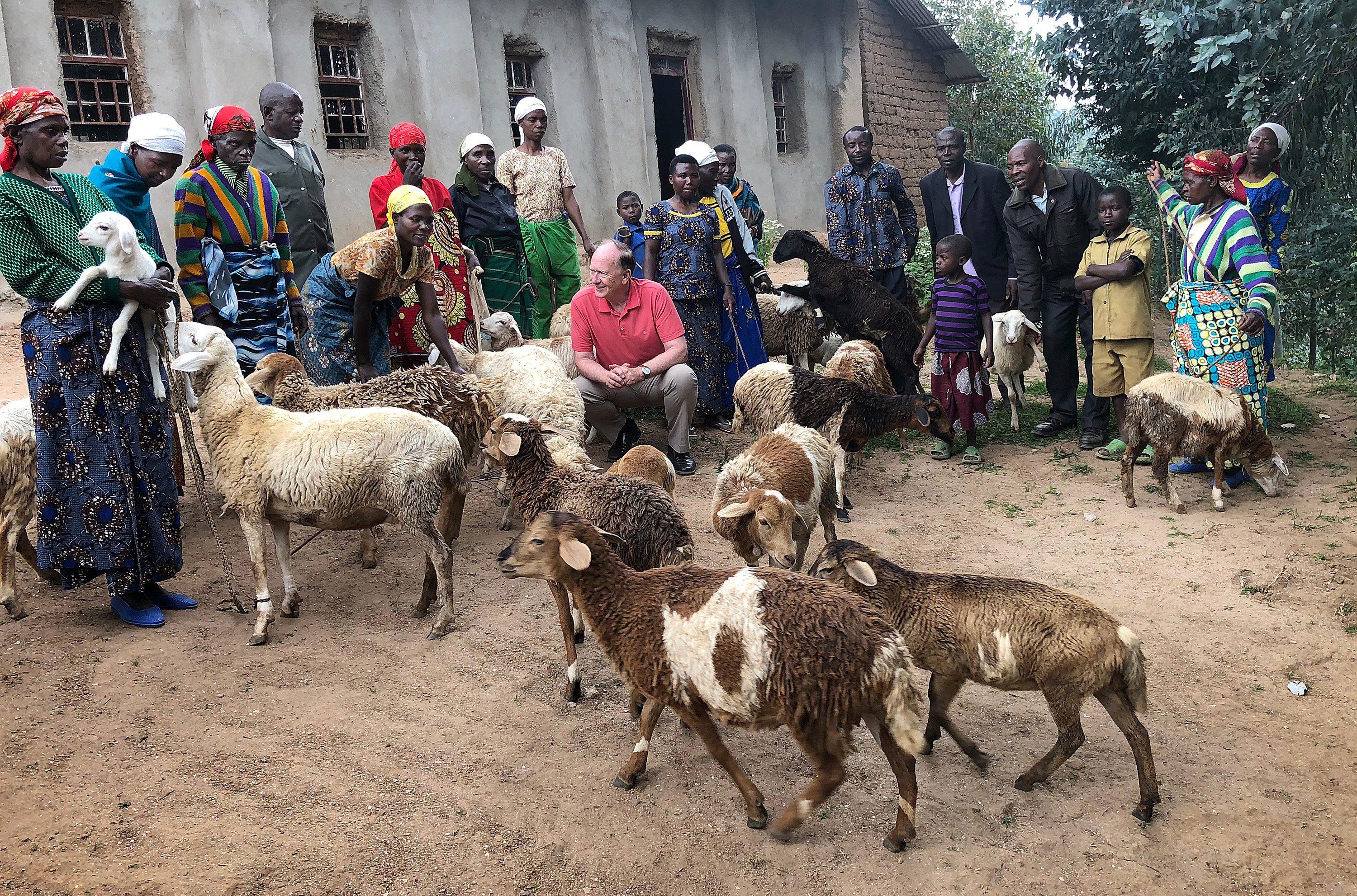 The Rev. Donald E. Messer (kneeling) meets some of the 60 Rwandan women who received sheep from the Colorado-based Center for Health and Hope. The sheep were purchased by individuals in the U.S. as Christmas gifts in honor of their family and friends. Photo courtesy of Donald E. Messer.