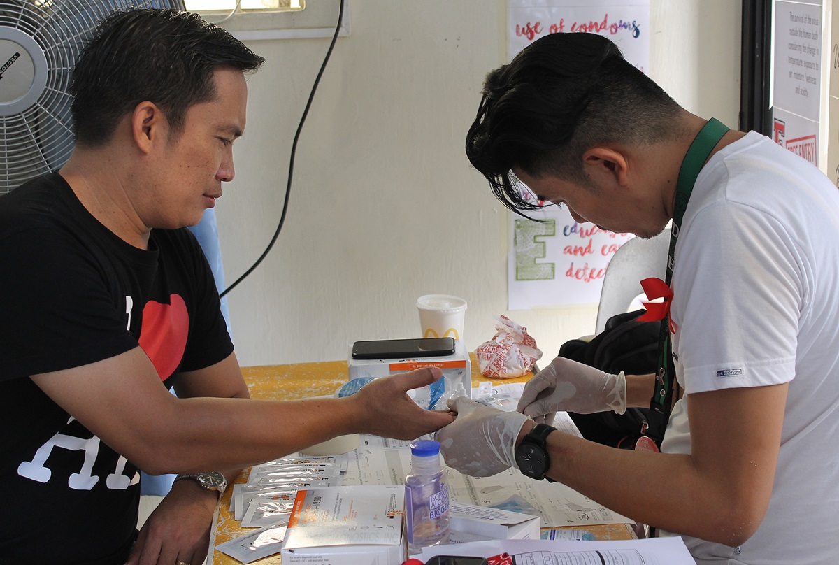 The Rev. Jeremias Dumaya (left) has blood drawn for HIV screening during a symposium on HIV and AIDS education at Wesleyan Third Millennium United Methodist Church in Cabanatuan City, Philippines. Photo by Gladys Mangiduyos, UMNS.