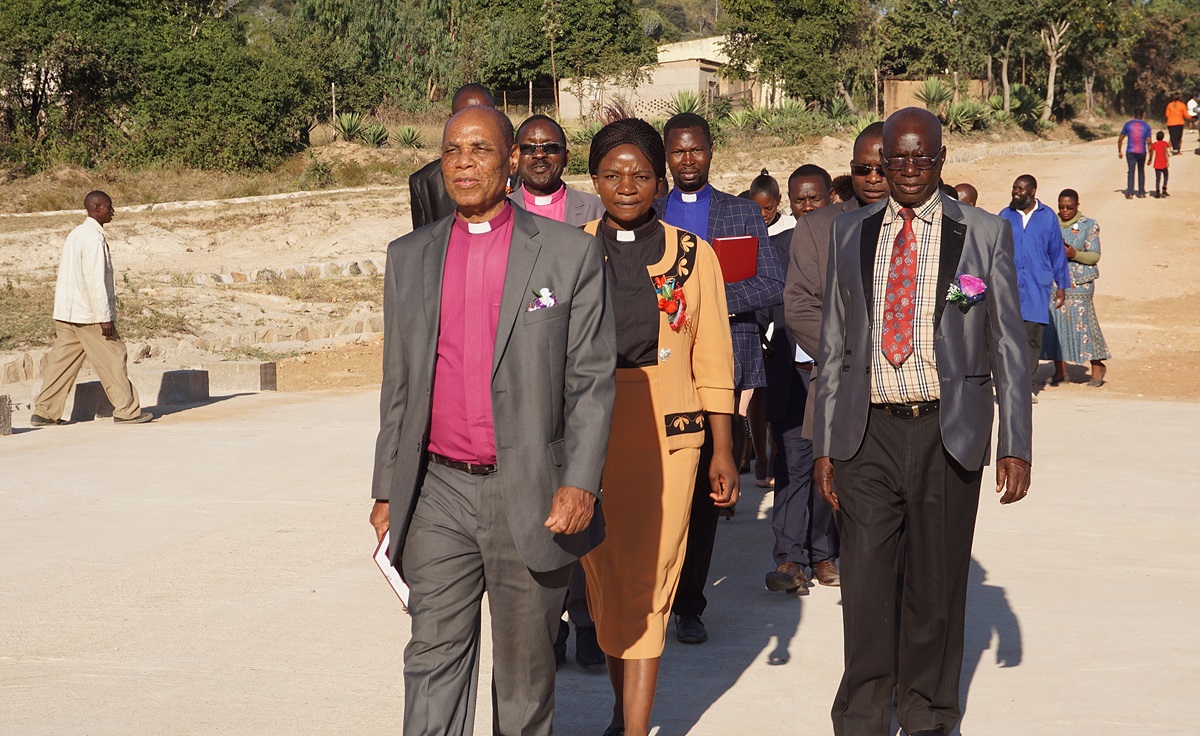 Bishop Eben K. Nhiwatiwa (front) leads the way across a new bridge commissioned by The United Methodist Church in Zimbabwe to connect United Methodist Marange High School near Mutare, to the local community. “The Nyadindwe Bridge will unite our communities as people cross to either side but also in religion, bridges can be spiritual, physical and mental in nature,” he said. Photo by Kudzai Chingwe, UMNS.