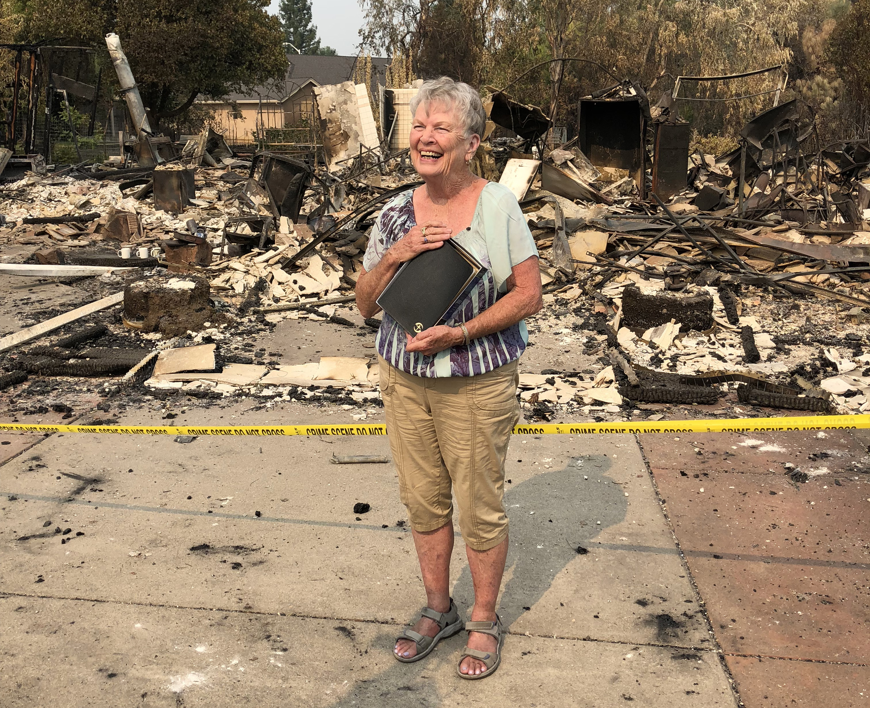 Charlotte Bailey clutches a Bible given to her by volunteers from Samaritan’s Purse, who sifted for valuables in the ashes of her home in Redding, Calif., which was destroyed by wildfire. Bailey is a member of Redding United Methodist Church. Photo courtesy of Charlotte Bailey.