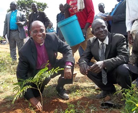 Bishop Eben K. Nhiwatiwa (front, left) plants a tree during the dedication of a bridge in Chitora, Zimbabwe in 2015. File photo by Taurai Emmanuel Maforo.