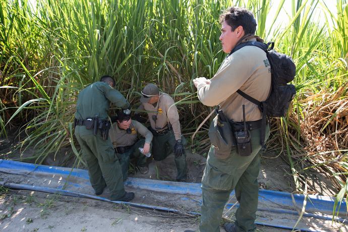 Border patrol agents come to the aid of a fellow agent who became overheated while searching a sugarcane field for people who entered the U.S. illegally. Photo by Mike DuBose, UMNS.