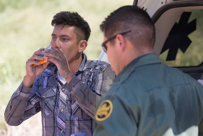 Border patrol agents come to the aid of a fellow agent who became overheated while searching a sugarcane field for people who entered the U.S. illegally. Photo by Mike DuBose, UMNS.