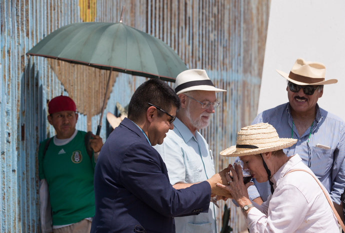 The Rev. John Fanestil, A United Methodist pastor, is visible through the steel mesh of the U.S. - Mexico border fence as he helps lead a cross-border service of Holy Communion from Friendship Park near San Diego on the U.S. side. Photo by Mike DuBose, UMNS.