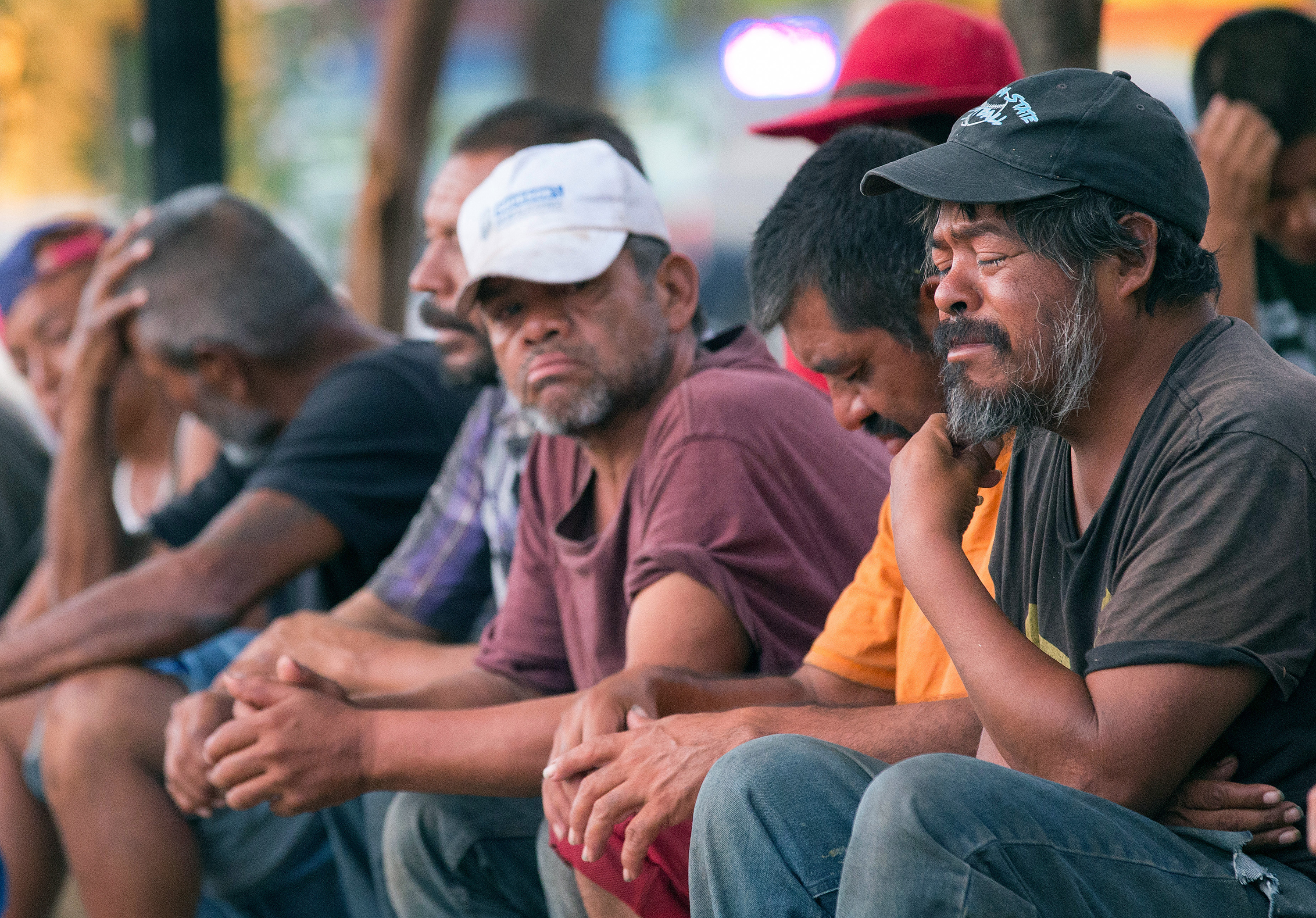 People living on the street, many of them migrants, pray during a worship service and dinner provided by El Divino Redentor Methodist Church at Mariachi Plaza in Mexicali, Mexico.