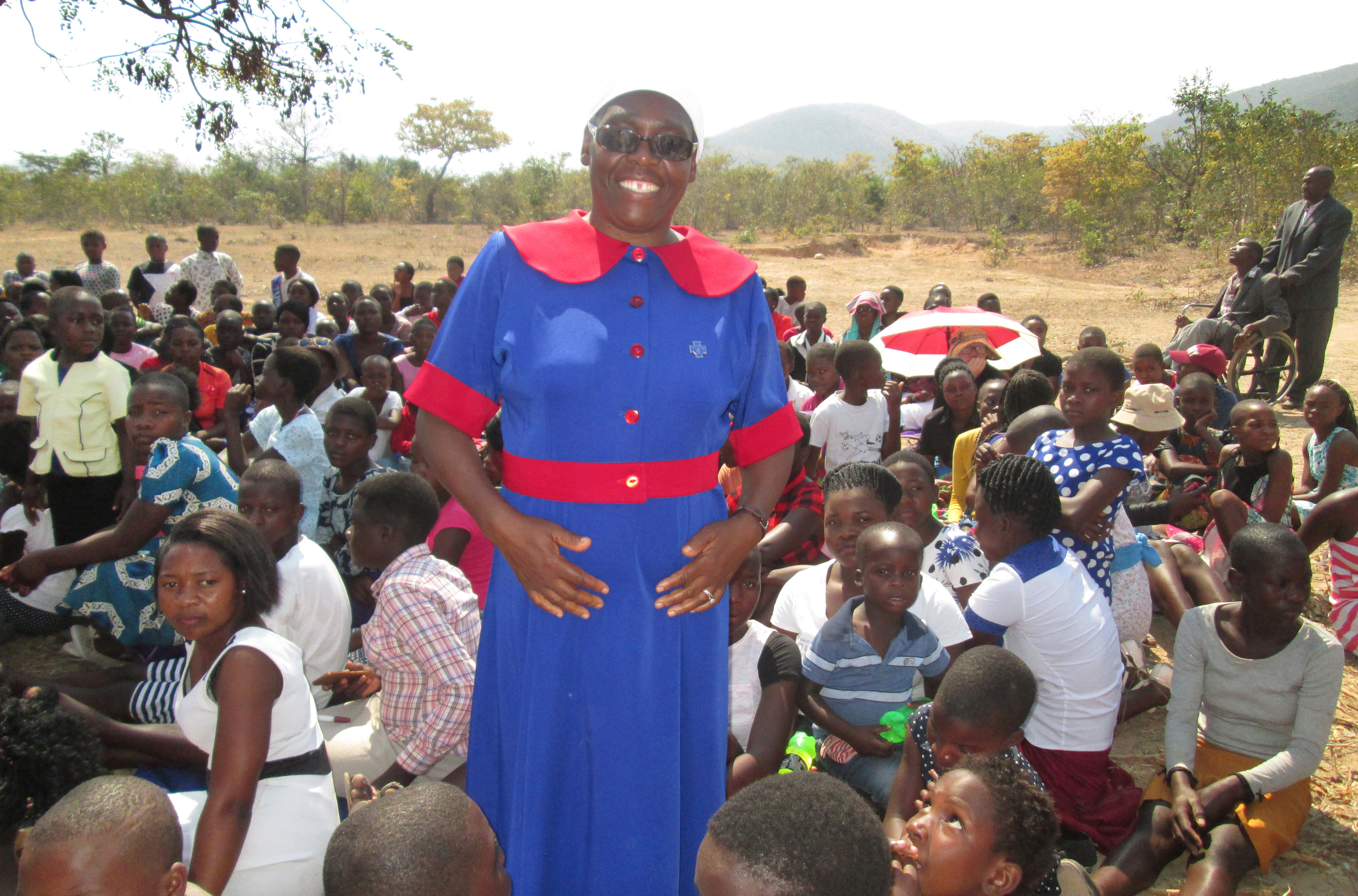 Rebecca Tendai Gurupira, speaker during an outreach program against violence and childhood marriages in Zimbabwe, stands surrounded by young people at the Nyambeya Camping site in the Chimanimani District.  Photo by Kudzai Chingwe, UMNS. 