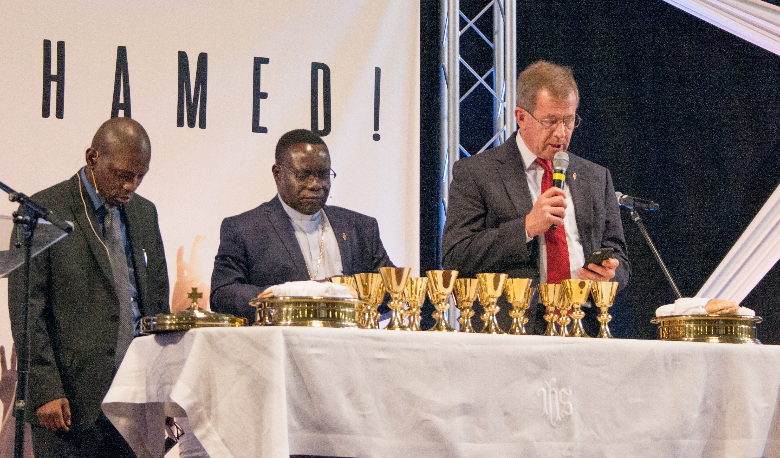Bishops Scott Jones (right) and Kasap Owan (center) celebrate the closing worship at the Wesleyan Covenant Association’s global celebration Nov. 3 in Marietta, Ga. Photo by Kathy L. Gilbert, UMNS.