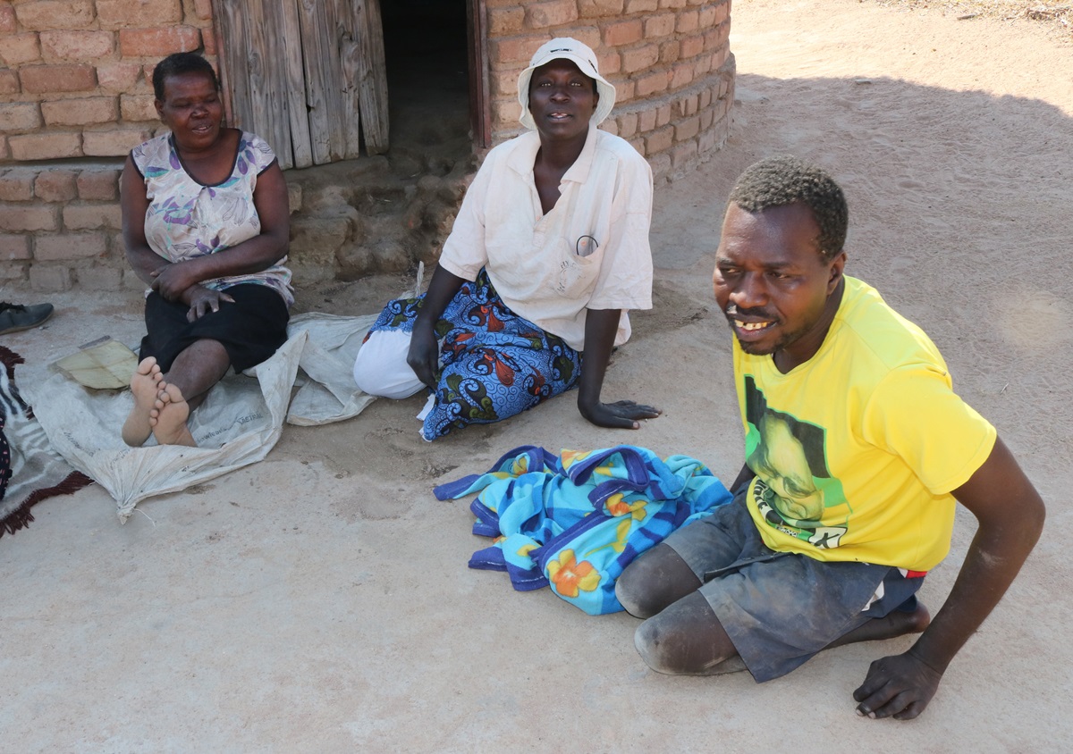 Givemore Martingarare (right in yellow T-shirt) awaits the distribution of a wheelchair in Chitendarano village in Nyazura, Zimbabwe. Photo by Chenayi Kumuterera, UMNS.  
