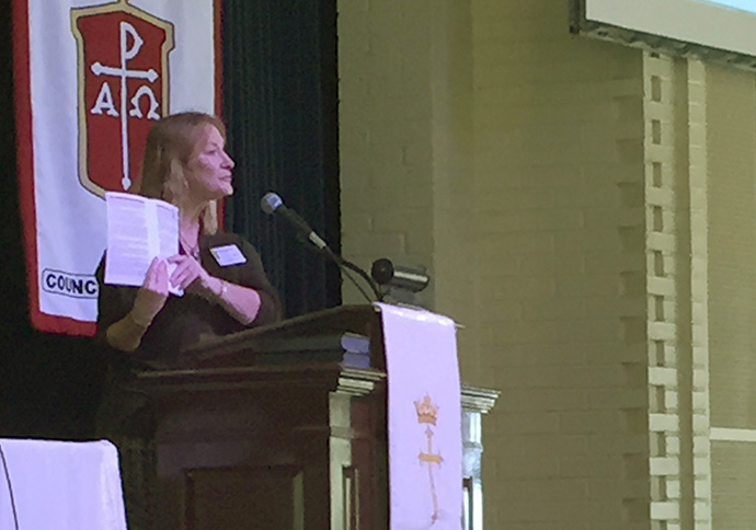 The Rev. Jean Hawxhurst, ecumenical staff officer, holds up the United Methodist ecumenical handbook during the Council of Bishops meeting. Photo by Heather Hahn, UMNS.