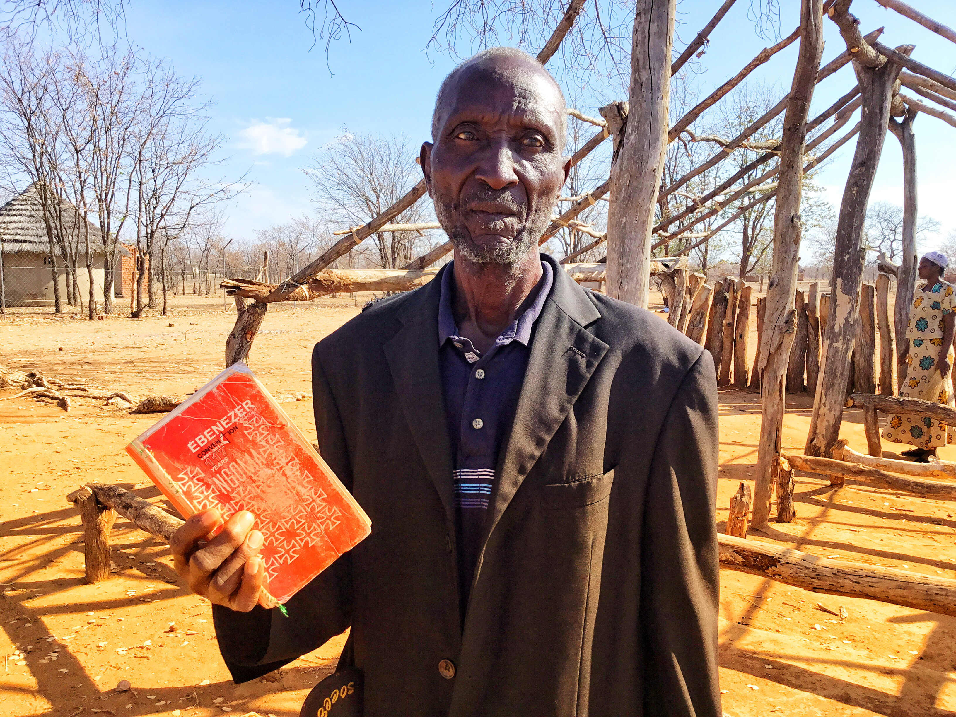 Edward Shanyurai, 80, holds an old United Methodist hymnal during outdoor worship in Muzarabani, Zimbabwe. Photo by Taurai Emmanuel Maforo, UMNS. 