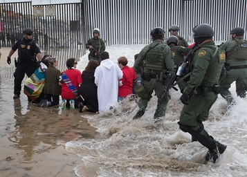 U.S. Border Patrol agents and officers from the Department of Homeland Security advance toward United Methodists leaders and organizers of a march calling for migrant justice as the marchers kneel on the beach at the fence between the U.S. and Mexico in San Diego. U.S. Border Patrol agents and officers from the Department of Homeland Security advance toward United Methodists leaders and organizers of a march calling for migrant justice as the marchers kneel on the beach at the fence between the U.S. and Mexico in San Diego.