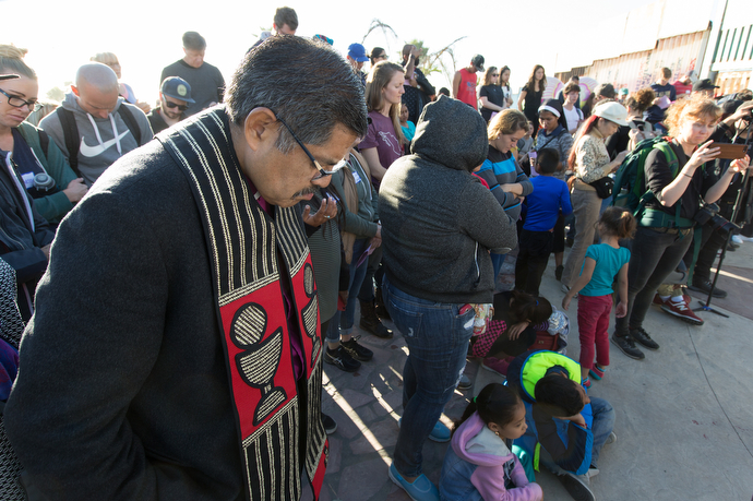 Bishop Felipe Ruiz Aguilar (left) of the Methodist Church of Mexico prays during the La Posada Without Borders celebration at El Faro Park in Tijuana, Mexico.