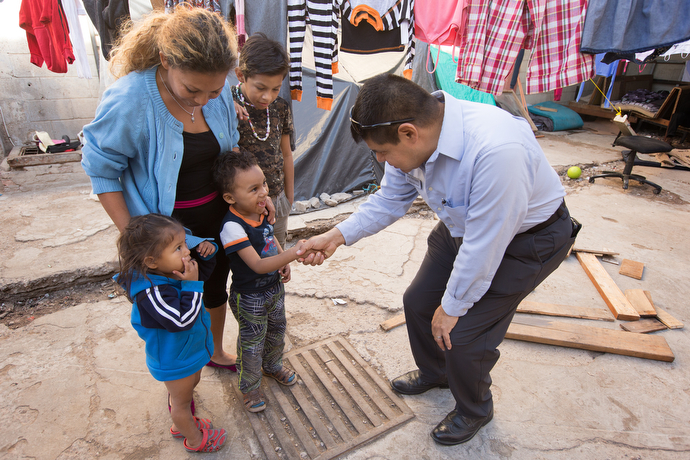 The Rev. Joel Hortiales (right), a United Methodist missionary with the Board of Global Ministries, visits with Lizbeth and her three children, Bridgette, 3, Caleb, 4 and Alvaro Jose, 10, at Hosanna Refugio Para Mujeres. The family is part of the migrant caravan that started its long journey on foot from Central American a few months ago.