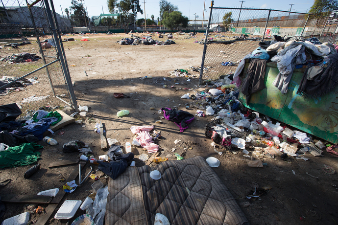 Discarded bedding, clothing and food containers litter the grounds of the Benito Juarez sports complex in Tijuana, Mexico, after many members of the migrant caravan left the makeshift camp for another with better sanitary conditions.