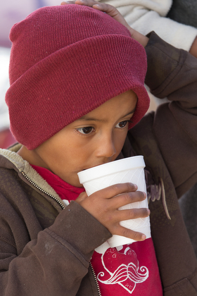 Franklin Garcia, 5, enjoys a cold drink while he waits with his mother for a meal at El Divino Redentor Methodist Church in Mexicali, Mexico.