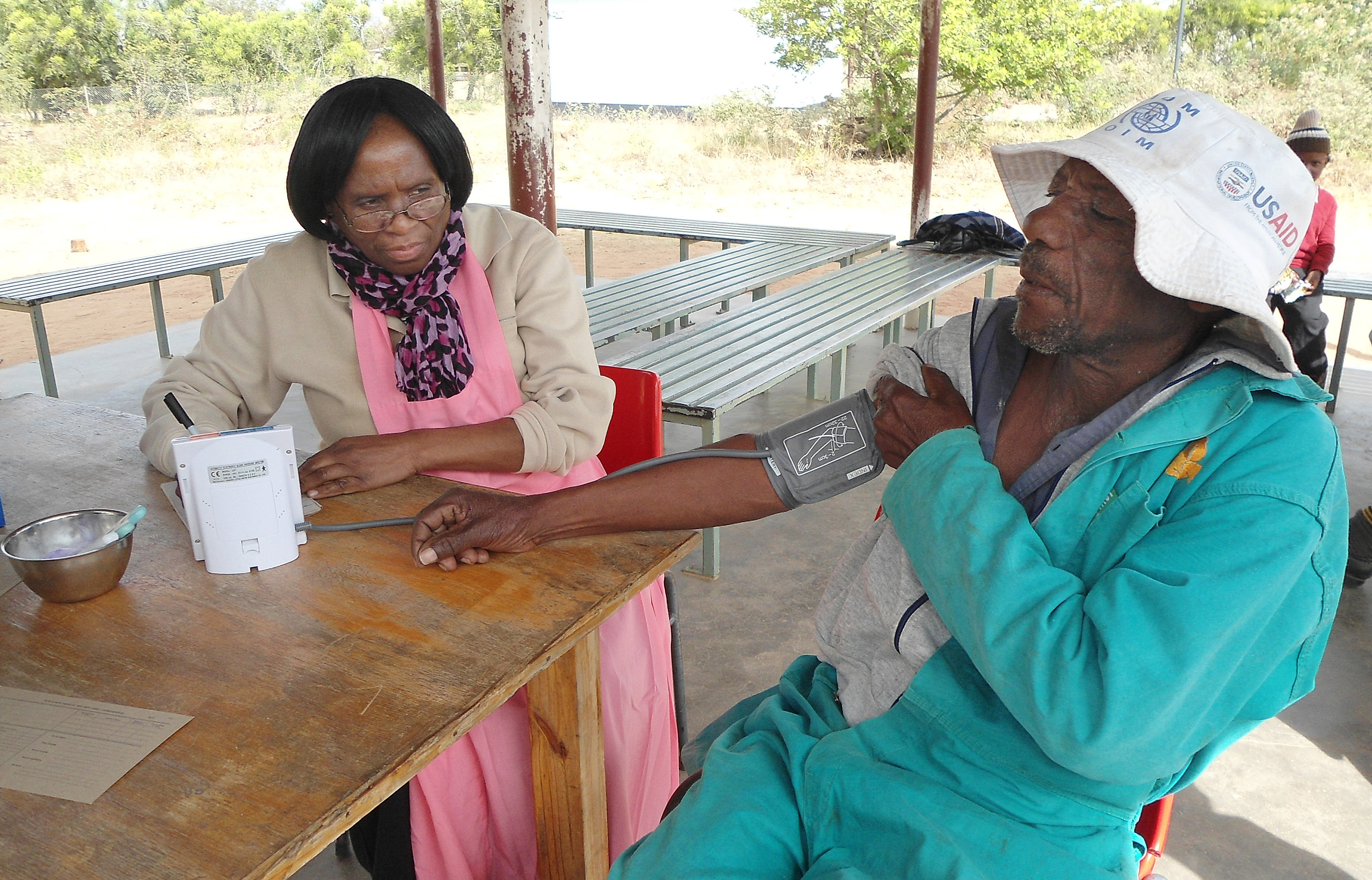 Joppa Muzokomba has his blood pressure checked by Killia Jena at a mobile clinic in Marange District sponsored by the Harare East District-Chisipiti Circuit in Zimbabwe. Photo by Kudzai Chingwe, UMNS.