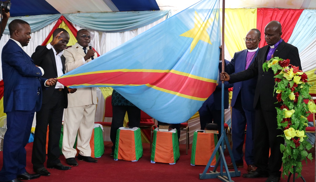 Bishops and leaders of different religious denominations pray while holding the Congolese flag. The Integrity and Electoral Mediation Commission, chaired by United Methodist Bishop Gabriel Yemba Unda (second from right), organized a service to promote peace before, during and after the elections. Photo by Chadrack Londe, UMNS. Bishops and leaders of different religious denominations pray while holding the Congolese flag. The Integrity and Electoral Mediation Commission, chaired by United Methodist Bishop Gabriel Yemba Unda (second from right), organized a service to promote peace before, during and after the elections. Photo by Chadrack Londe, UMNS.