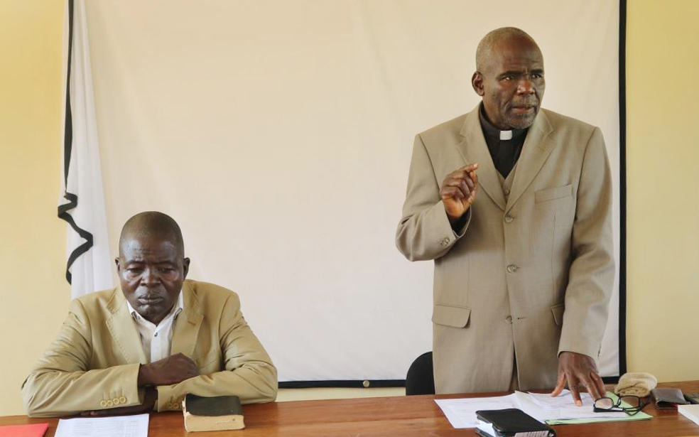The Rev. Ndjela Shango Paul, director of the department of Christian education, listens as the Rev. Kalema Tambwe, South Kindu District superintendent, speaks during the opening of The United Methodist Church’s annual health council in December. During the gathering, the church decided to double its efforts in the fight against Ebola. Photo by Chadrack Tambwe Londe, UMNS.