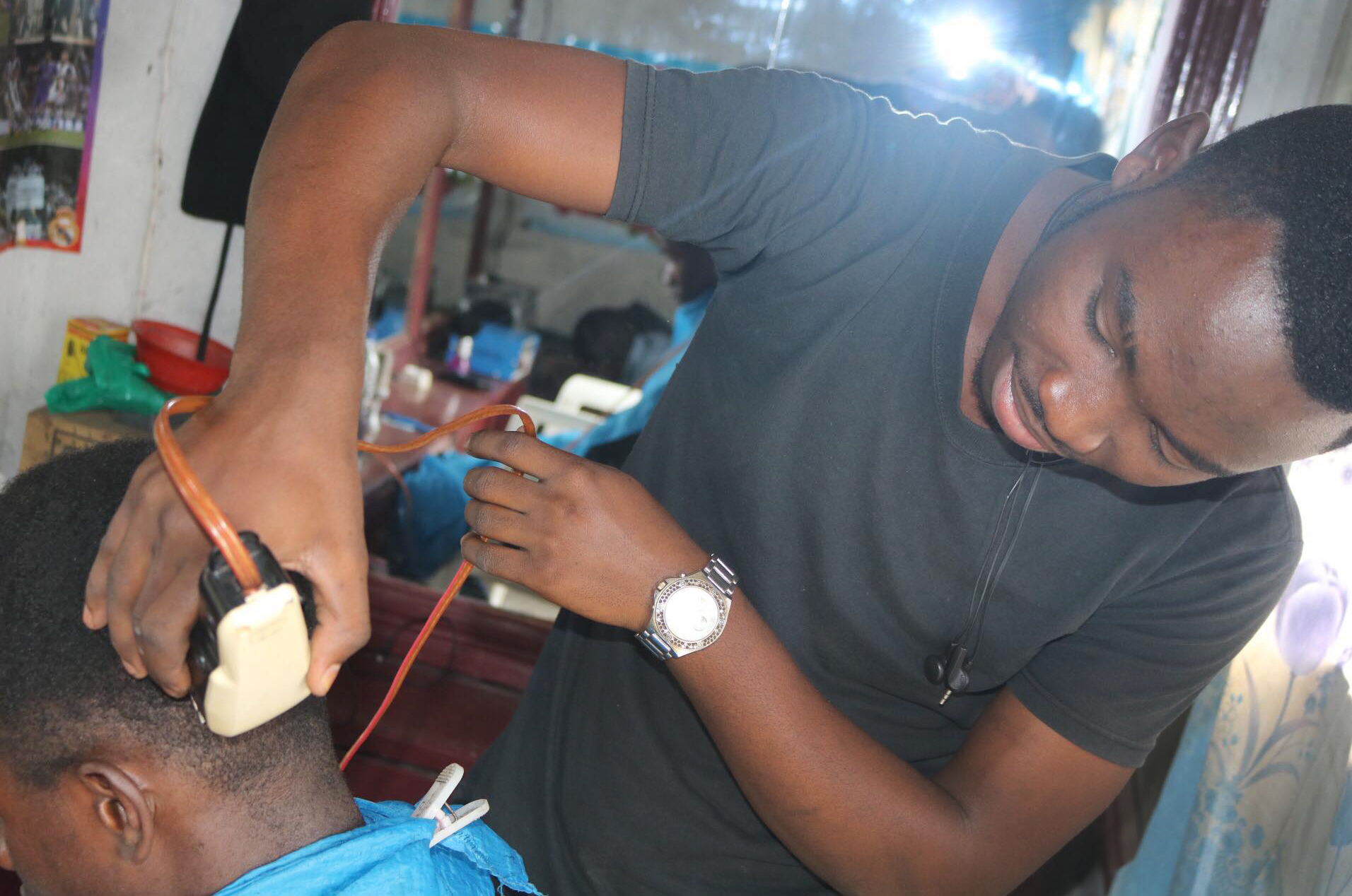 Thierry Muhindo, 17, a former street child, grooms a customer in Goma, Congo. Muhindo was taught to style hair by the Kivu Youth Peace Club. Photo by Philippe Kituka Lolonga, UMNS.