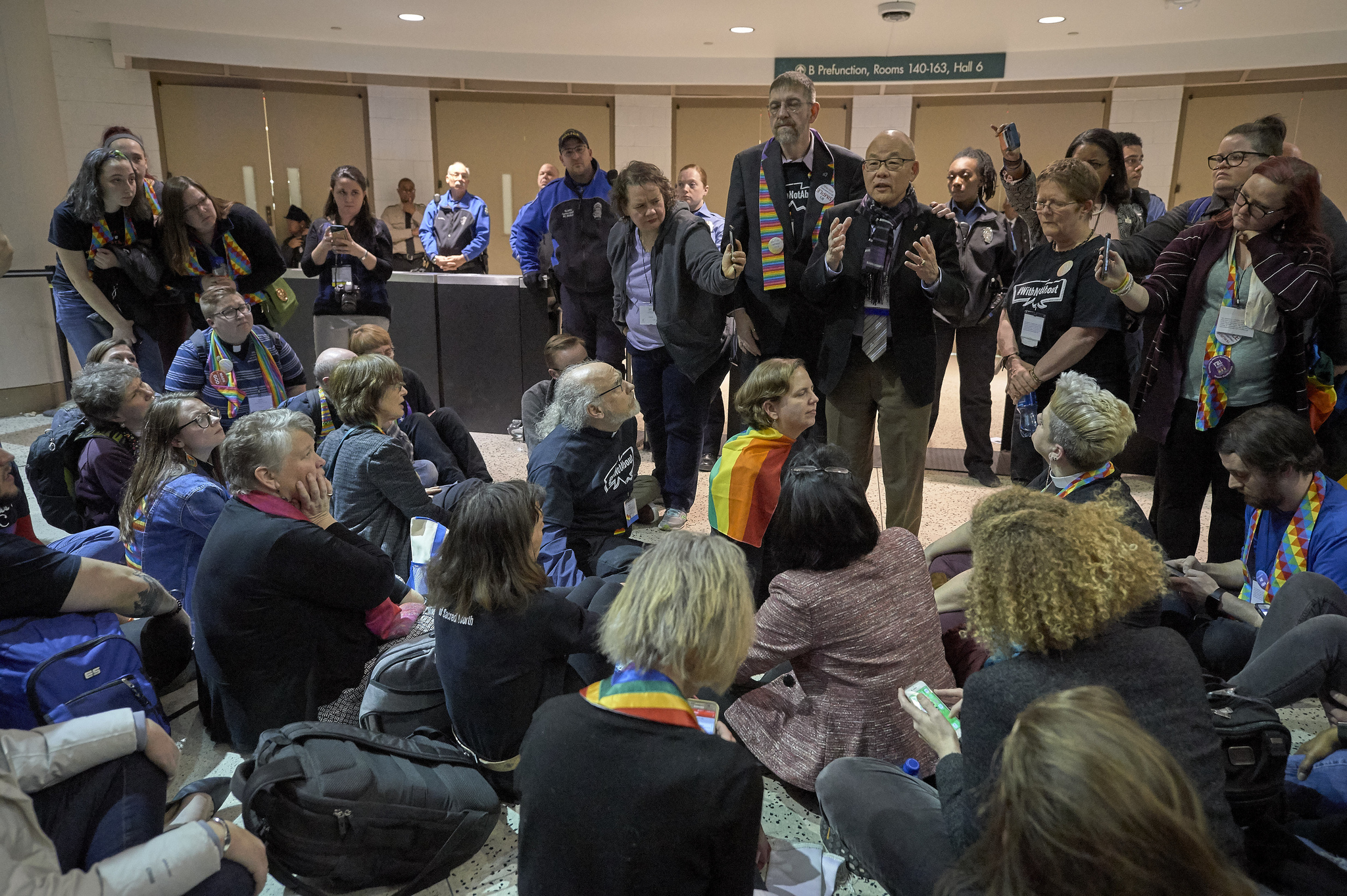 El obispo metodista Robert Robert Hoshibata se reúne com manifestantes para a aprovação do Plano Tradicional, que concretiza as proibições da lei de ordenar por todo o mundo LGBTQ y oficiar o celebrar bodas entre personas del mismo sexo. A votação se realizou na última día da Conferencia Geral de 2019, em San Luis. Foto por Paul Jeffrey, SMUN.